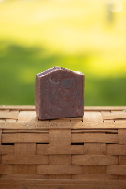 Mulled Orchard bar soap on a wicker basket with a blurred green outdoor background
