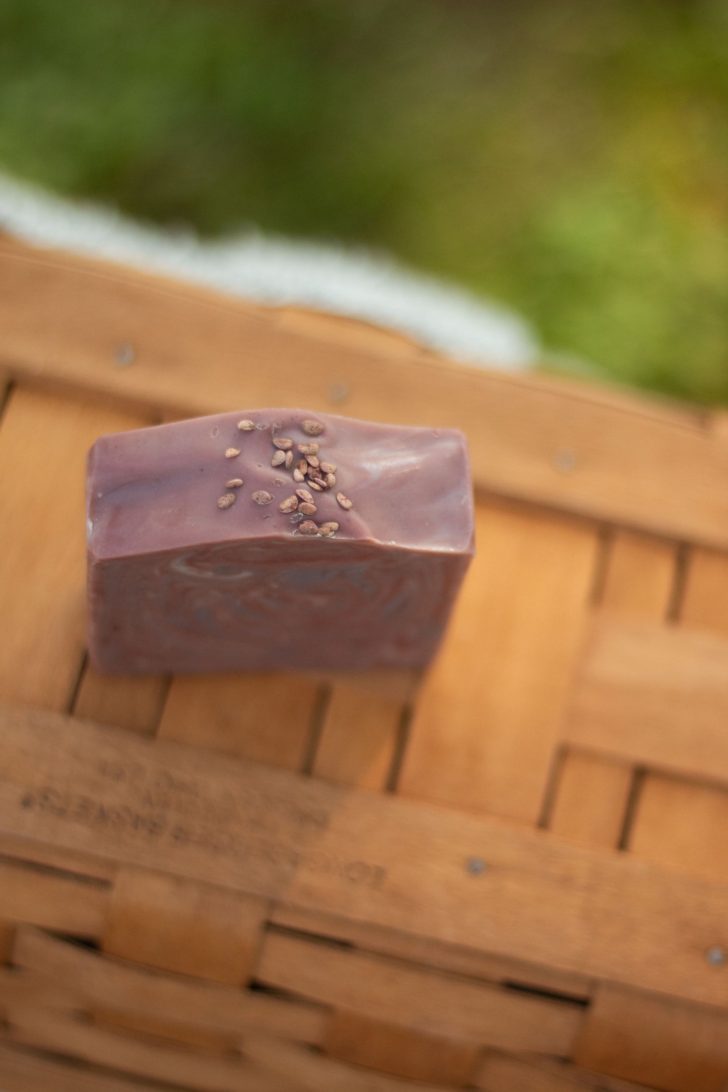 Close-up of Mulled Orchard bar soap resting on a wicker basket