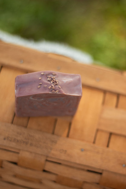 Close-up of Mulled Orchard bar soap resting on a wicker basket
