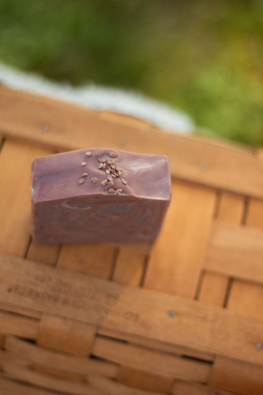 Close-up of Mulled Orchard bar soap resting on a wicker basket