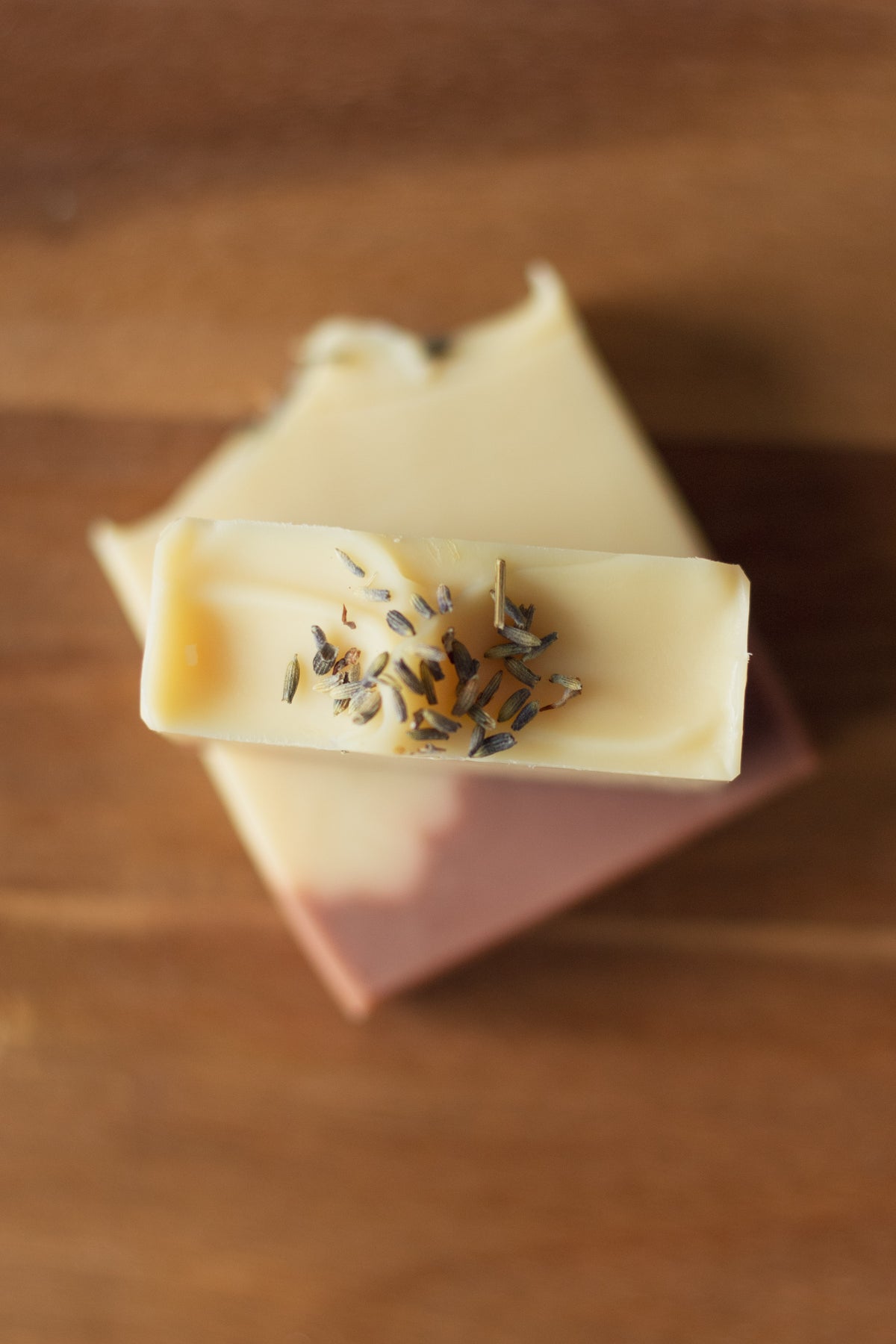 Top-down view of a Lemon + Lavender soap bar with dried lavender buds pressed into the top